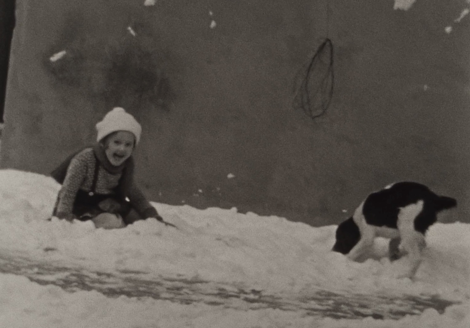 Still uit een film uit Tilburg jaren '30, meisje en hond in de sneeuw